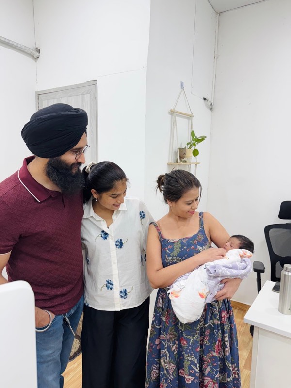 Dr. Payal Aggarwal with parents and their newborn at the clinic